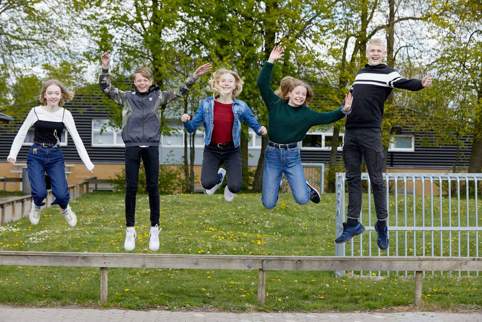 Elever hopper op i luften i skolegården