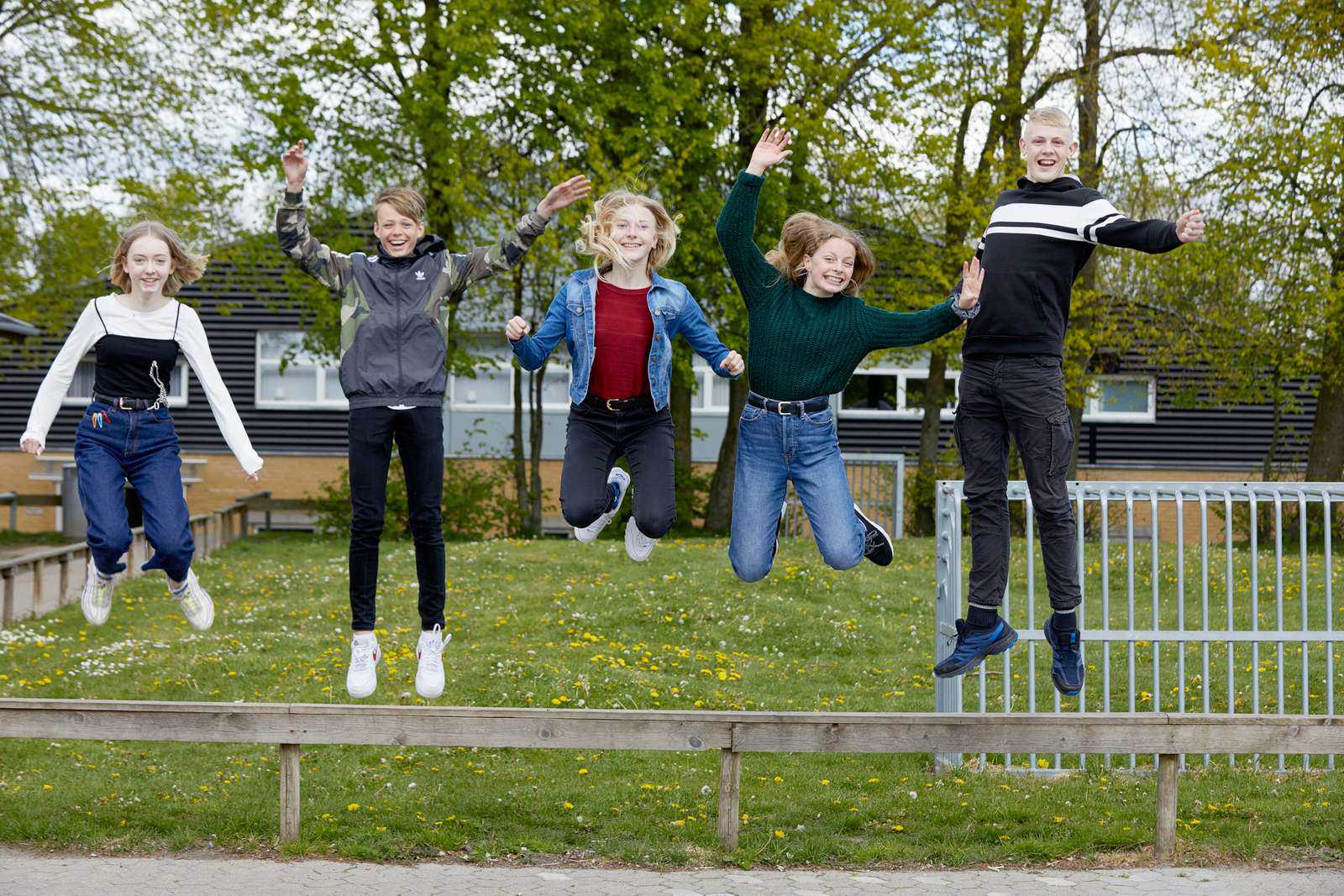 Elever hopper op i luften i skolegården