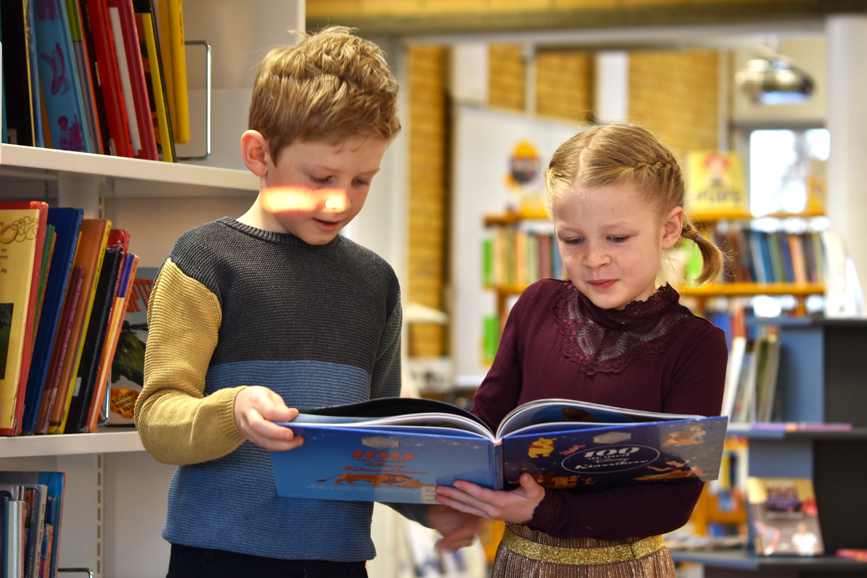 Børn kigger i bog på Korshøjskolen