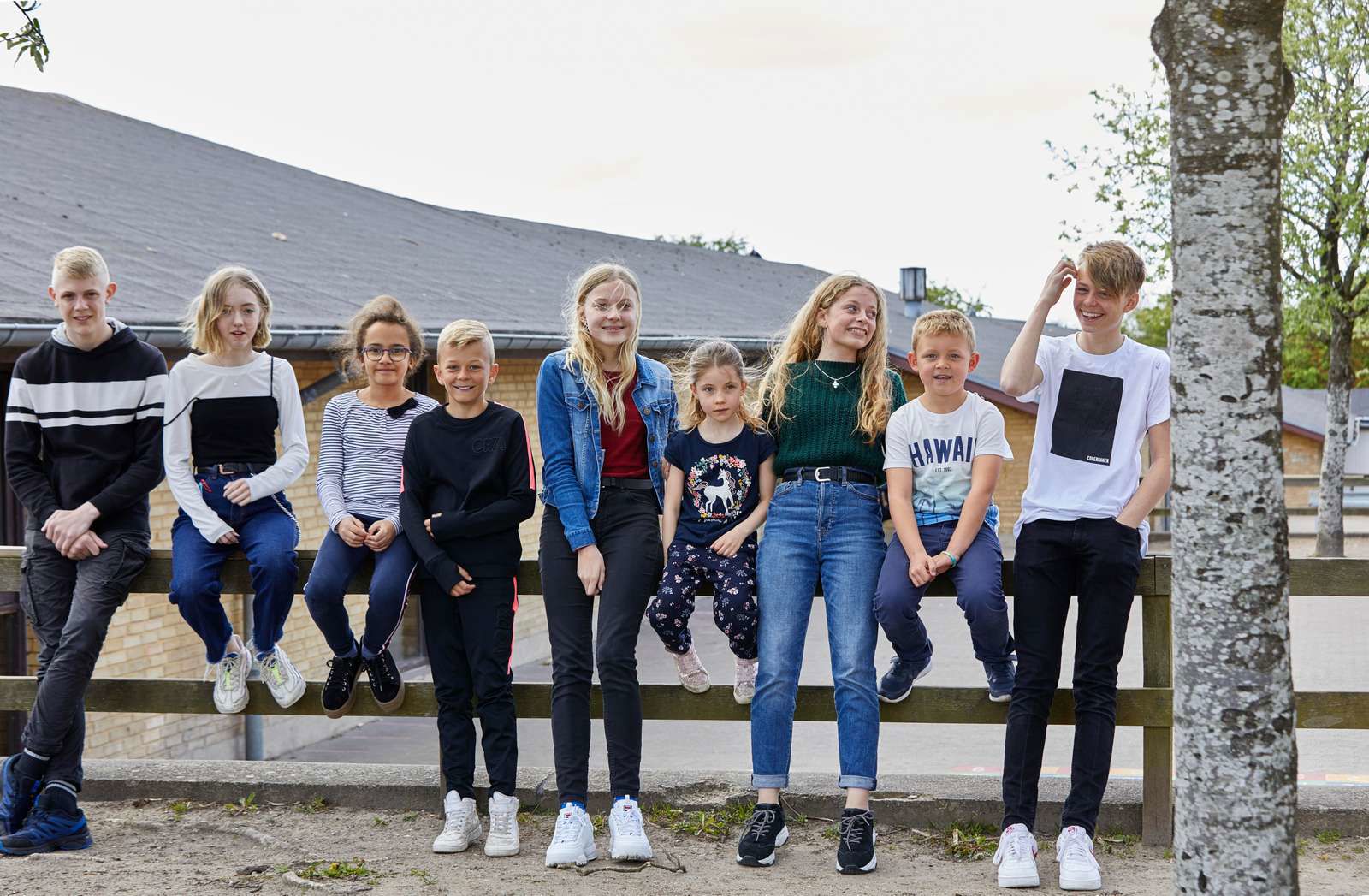 Elever sidder foran skole